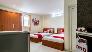 Ein Schlafzimmer mit zwei Betten, einem Kleiderschrank und einem Fenster.