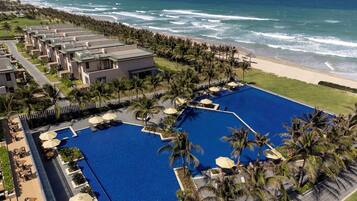 Un resort con una gran piscina, acceso a la playa y varias edificaciones.