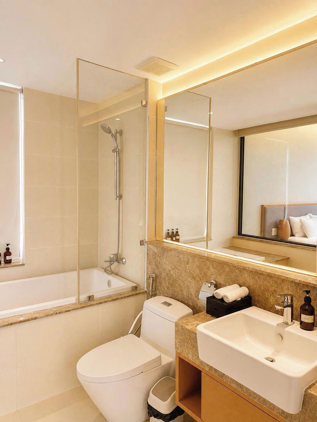 Un baño moderno con ducha envuelta en vidrio, inodoro, lavamanos y espejo.