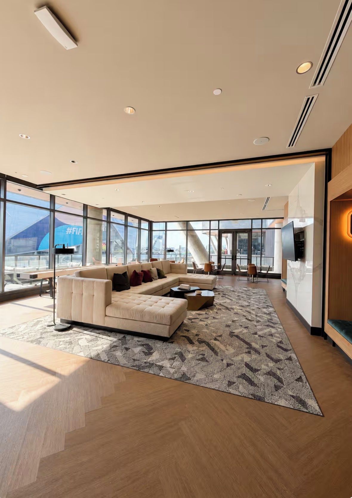 A modern living room with a large sofa, a coffee table, and a patterned rug.
