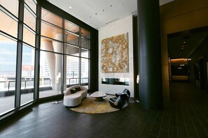 A modern lobby with large windows, a round coffee table, and a sofa. - Cozy 1-bedroom apartment in charming Atlanta with AC and gym access (Atlanta)