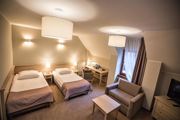 A hotel room with two single beds, a desk, a chair, and a TV. - Pod Szyszkami (Krotoszyn)