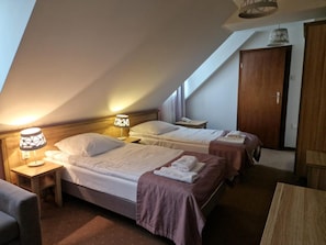A hotel room with two beds, a desk, a chair, and a wardrobe. - Pod Szyszkami (Krotoszyn)