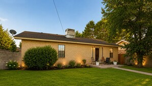 A single-story house with a brick exterior, a front porch with seating, and a well-maintained lawn. - Vintage Charm-Modern Comfort•2BR/2BA home (Lovington)
