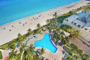 Ein Resort mit Pool, Strand und Palmen.
