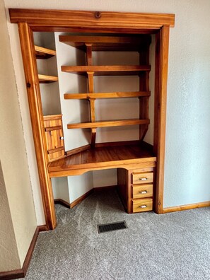 A corner storage unit with multiple shelves and drawers.