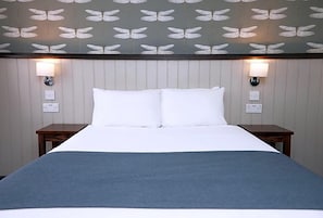 Ein Hotelzimmer mit einem Bett, zwei Nachttischen und Wandlampen.