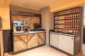 Eine Selbstbedienungs-Kaffeestation und eine Station für Gewürze und Beilagen, jeweils mit beschrifteten Behältern.