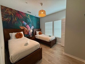 A bedroom with two beds, a large mural on the wall, and a window with blinds. - 8947 SD - 4BR Home in West Lucaya | Near Disney (Kissimmee)