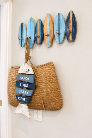 A wall with surfboards and a woven bag with labels. - Buddina Boutique Coastal Studio on the Waterfront (Buddina)