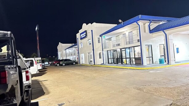 A parking lot with a building that has a blue roof and a sign that reads 'JOURNAL'. - Your Place to stay! Big SEC Clash 1 Bedroom King Bed. Dreamland Inn in Senatobia (Senatobia)