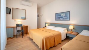 A hotel room with two beds, a desk, a chair, a TV, and a painting on the wall. - Parigi (Caorle)