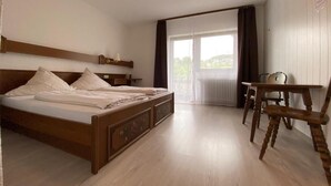 A hotel room with a bed, a desk, and a chair. - Alemannenhof Engel (Rickenbach)