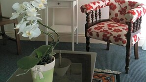 Une pièce comprenant une chaise, une table, une lampe et un tableau accroché au mur.