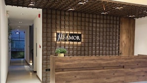 A reception desk with a wooden panel design and a sign that reads 'MI-AMOR'. - DD Hospitality - Mi Amor Da Lat (Xuan Huong - Da Lat)