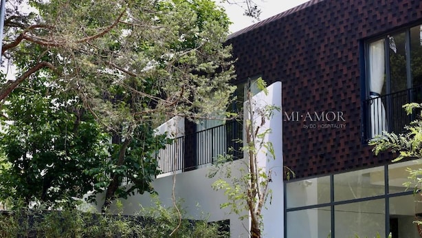 A modern building with a brick facade and large windows, labeled 'MI AMOR by DD HOSPITALITY.' - DD Hospitality - Mi Amor Da Lat (Xuan Huong - Da Lat)