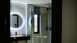 A modern bathroom with a glass shower enclosure, a round mirror, and a vanity with a lighted mirror. - DD Hospitality - Mi Amor Da Lat (Xuan Huong - Da Lat)