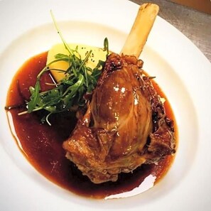 A plate with a meat dish, greens, and a slice of potato. - Green Tree Hotel (Peebles)