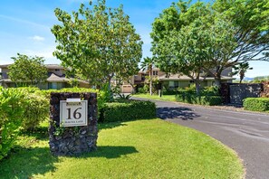 A residential area with a stone sign indicating 'KULALANI 16 MAUNA LANI.' - 🏖️Two King Ensuite Bedrooms + Pools & Hot Tubs (Kamuela)
