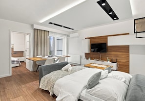 Ein modernes Hotelzimmer mit Bett, Schreibtisch und Fernseher.