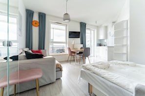 Ein modernes Hotelzimmer mit einem Bett, einem Sofa, einem Schreibtisch und einem Fernseher.
