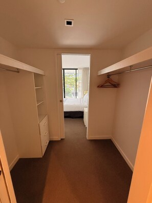 Un dormitorio con cama, armario y ventana.