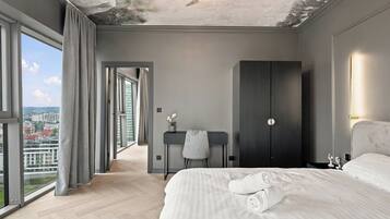 Ein modernes Hotelzimmer mit einem großen Bett, einem Schreibtisch und Blick auf die Stadt.