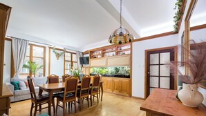 Eine ger äumige Küche mit Holzausstattung, einem Esstisch und Stühlen.