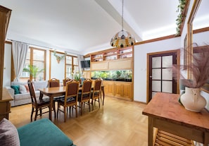 A spacious kitchen with wooden cabinets, a dining table, and chairs. - Piwna Old Town Residence Apartment (Warszawa)