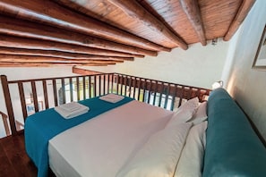 A room with a bed, a balcony, and wooden beams. - C/da Pozzetti Apartment (Lascari)