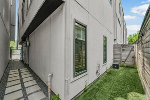 A narrow pathway leading to a building with a small lawn area. - Luxury Retreat Near Memorial & Heights. Sleeps 8 with Wellness Studio (Houston)