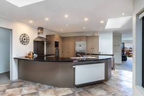 A modern kitchen with a central island, built-in appliances, and a skylight.