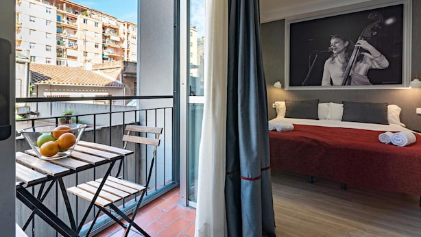A balcony with a table, chairs, and a bowl of fruit. - Hot Jazz 51 (Barcelona)
