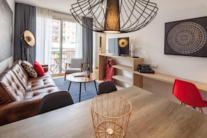 En moderne stue med en lædersofa, et spisebord og en rød stol.
