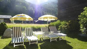 Outdoor seating with umbrellas and a view of a mountainous landscape.