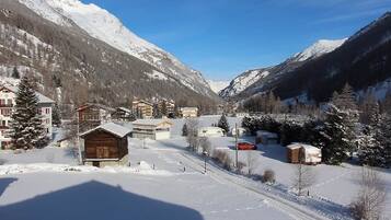 A snow-covered mountain village with wooden buildings and a clear sky.