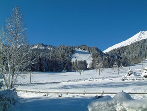 A snow-covered landscape with a mountain in the background and a clear blue sky. - Aegertenstrasse 18 # 1 - Two Bedroom (Lenk)