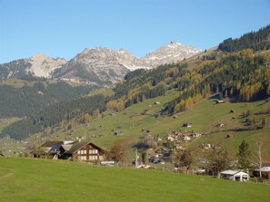 A rural landscape with a village, green fields, and mountains in the background. - Aegertenstrasse 18 # 1 - Two Bedroom (Lenk)
