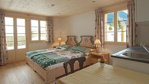 Une chambre à coucher avec un lit, une table de chevet, une lampe et une vue sur l’extérieur par une fenêtre.