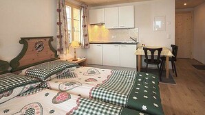 Une chambre avec un lit, un bureau et une kitchenette.