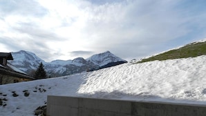 Un paysage enneigé, avec des montagnes en arrière-plan et une structure en béton au premier plan.