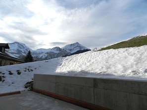 A snow-covered landscape with mountains in the background and a concrete structure in the foreground. - Mutthorn - One Bedroom (Lauenen)