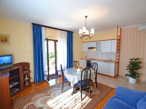 A compact living space with a dining area, kitchenette, and a television. - Stana - One Bedroom (Zadar)