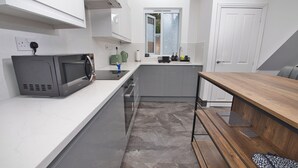 Una cucina moderna con microonde, tostapane e lavello.