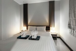 A hotel room with a large bed, two nightstands, and a headboard with vertical lines. - Elyana -Serene 3BR Pool Villa Retreat (Tambon Rawai)