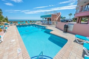 A pool area with lounge chairs, a pool, and a view of the ocean. - Breathtaking Ocean Views Your Beachside Getaway (Myrtle Beach)