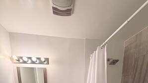 A bathroom with a vanity, toilet, and shower. - Charming Historic 2BR Townhouse 10-Min PATH Ride to NYC (Jersey City)
