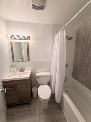 Une salle de bain équipée d’un meuble-lavabo, de toilettes et d’une douche.