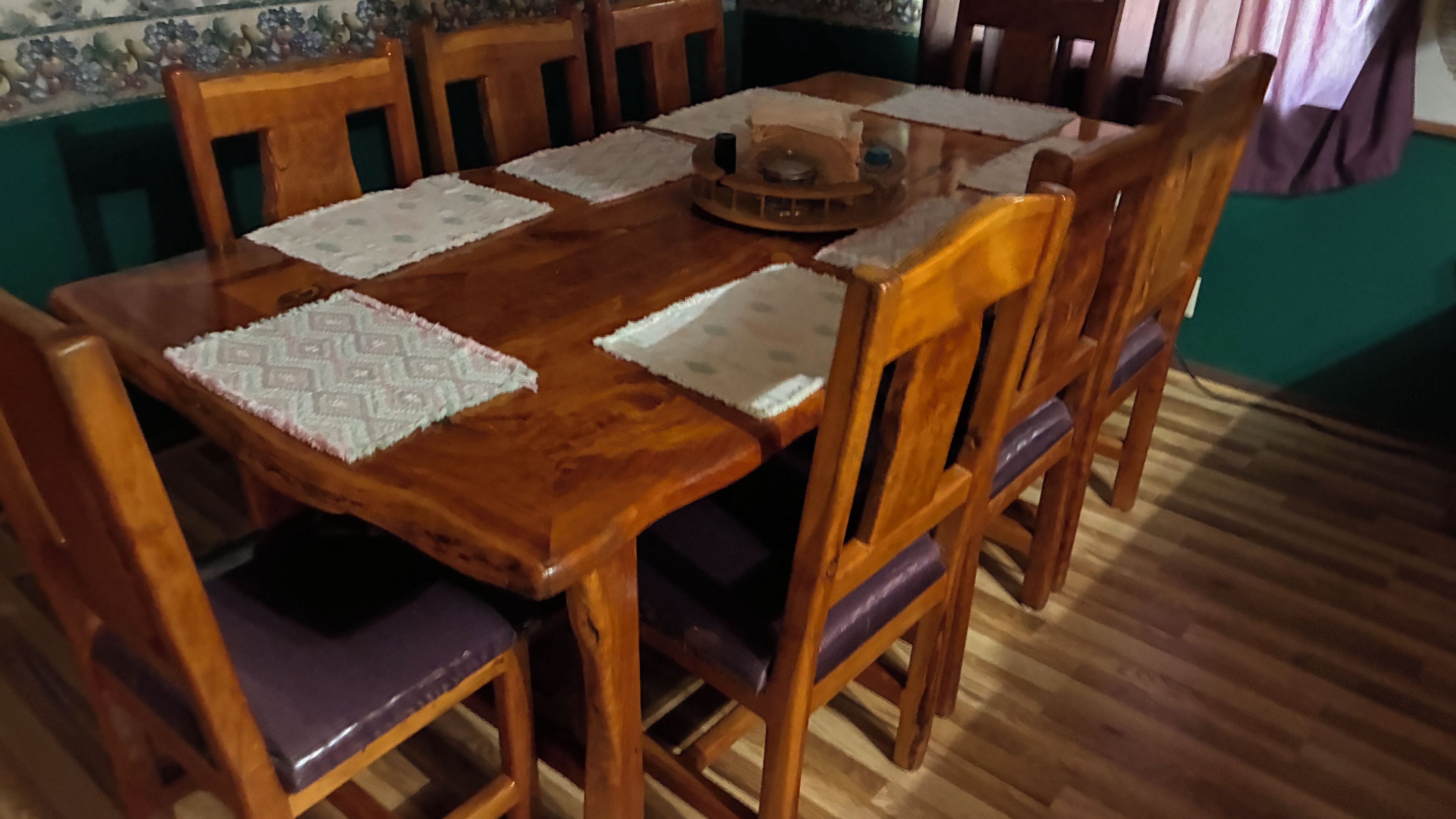 Une table de salle à manger en bois, accompagnée de quatre chaises, chacune dotée d’un siège rembourré.