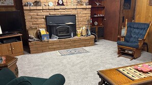Ein Wohnzimmer mit Kamin, Fernseher und einer gemütlichen Sitzecke.